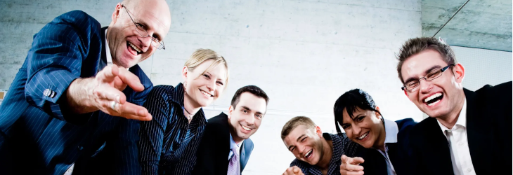 A group of people around a meeting table pointing and laughing at you, the reader.