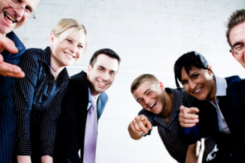 A group of people at a meeting table pointing and laughing at you, the reader