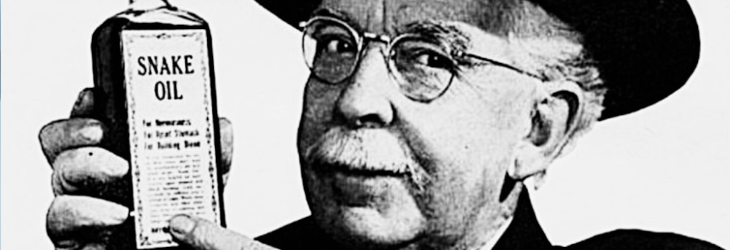 A vintage image of a man in a hat witha moustache holding up a bottle of snake oil, pointing to it and looking at that camera as if to say 'oh brother, check THIS one out'